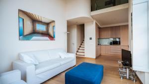 a living room with a white couch and a blue stool at Virgilio 2 - Villa Bice in Alassio
