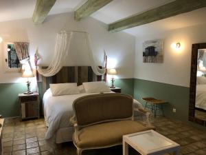 1 dormitorio con 1 cama y 1 silla en Mas Lou Piastoun, en Fayence
