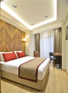 a hotel room with a large bed and a desk at Celine Hotel Taxim in Istanbul