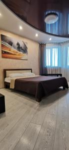 ein Schlafzimmer mit einem großen Bett und Holzboden in der Unterkunft Романтичні апартаменти у центрі in Luzk