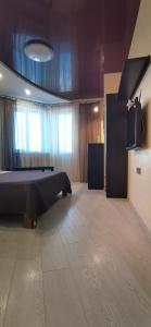 ein Schlafzimmer mit einem Bett und einem TV in der Unterkunft Романтичні апартаменти у центрі in Luzk