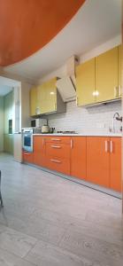 eine leere Küche mit orangefarbenen Schränken und einem Waschbecken in der Unterkunft Романтичні апартаменти у центрі in Luzk