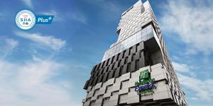 a large building with a clock on it's side at Holiday Inn Express Bangkok Siam, an IHG Hotel - SHA Extra Plus in Bangkok
