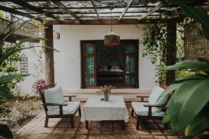 een patio met een tafel en stoelen en een raam bij Villa Akasa in Varkala