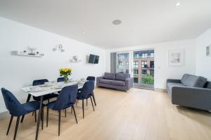 uma sala de estar com uma mesa e cadeiras e um sofá em Regents North London Apartments em Londres