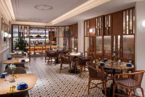 Kimpton Vividora Hotel by IHG في برشلونة: مطعم به طاولات وكراسي وبار