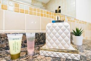 a bathroom counter with a bottle of cleanser and a soap dispenser at LiveIn Holiday Homes - JBR in Dubai