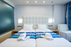 two seagulls sitting on a bed in a room at Konstantinos Palace in Karpathos