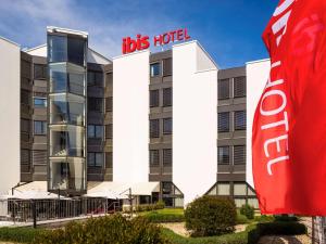 a hotel in front of a building with a cola sign at ibis Lausanne Crissier in Lausanne