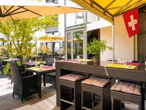 a restaurant with a bar and tables and chairs at ibis Lausanne Crissier in Lausanne