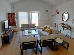 uma sala de estar com um sofá, cadeiras e uma mesa em Villa Gallotia em Las Puntas