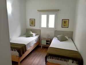 two beds in a small room with a window at Villa Gallotia in Las Puntas