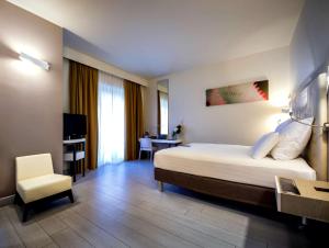 una camera d'albergo con letto e sedia di Pullman Almar Timi Ama Resort & Spa a Villasimius