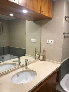 eine Badezimmertheke mit zwei Waschbecken und einem Spiegel in der Unterkunft Charming Deluxe Apartment in Oeiras