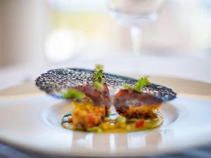 a plate with some food on a table at Almar Timi Ama Resort & Spa in Villasimius
