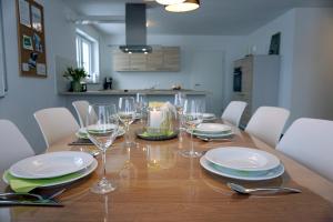 - une table à manger avec des assiettes et des verres à vin dans l'établissement Ferienwohnung Reimann mit kostenloser AlbCard, à Blaubeuren