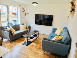 a living room with two couches and a table at Stylish New Build with Garden and Free Parking in Taunton
