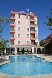 a hotel with a swimming pool in front of a building at Megas Hotel in Ayvalık