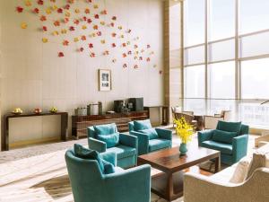常熟的住宿－常熟理文鉑爾曼酒店，一间设有蓝色椅子和桌子的等候室