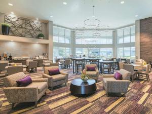 a lobby with chairs and tables and a bar at La Quinta by Wyndham Austin at The Domain in Austin