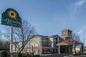 a building with a sign for a sunni king suites at La Quinta by Wyndham Kansas City Airport in Kansas City