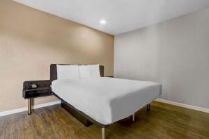 a white bed in a room with a wall at Motel 6-Ukiah, CA - North in Ukiah