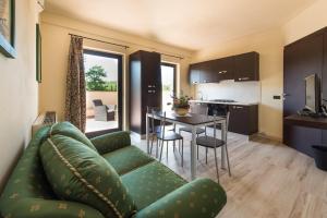 un soggiorno con divano verde e tavolo di Residenze Pianetti a Manciano
