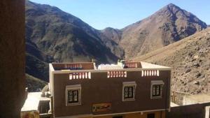 un edificio con una montagna sullo sfondo di Gite Dar Tanzoughte a Imlil