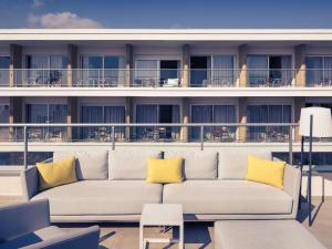 a couch on the balcony of a cruise ship at Mercure Villeneuve Loubet Plage in Villeneuve-Loubet