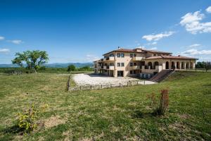 a large house on a hill with a yard at Residenze Pianetti in Manciano