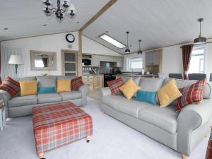 a living room with two couches and a kitchen at Beachcliff in Newquay