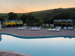 a resort with a pool with lounge chairs and tents at Beachcliff in Newquay