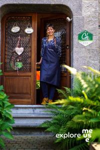 una mujer parada en la puerta de una casa en Au Plaisir en Hastière-par-delà