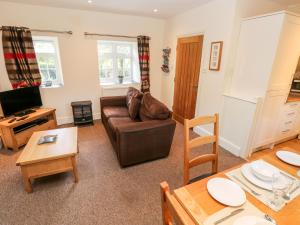 a living room with a couch and a table at Swallows Cottage in Walton East