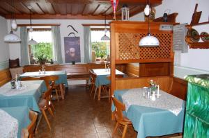 a restaurant with tables and chairs with blue tablecloths at Gasthof Grabenwirt in Irdning