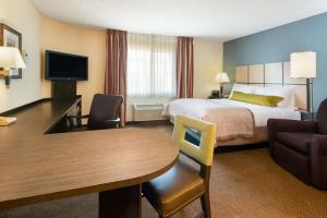 a hotel room with a bed and a table at Sonesta Simply Suites Philadelphia Mount Laurel in Mount Laurel