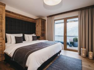 a bedroom with a large bed and a large window at VAYA St Zeno Serfaus in Serfaus