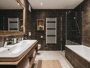 a bathroom with a sink and a tub and a shower at VAYA St Zeno Serfaus in Serfaus