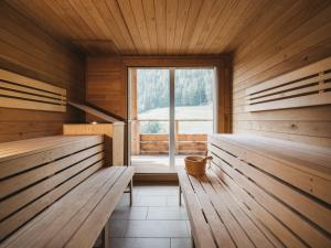 a sauna with wooden benches and a window at VAYA St Zeno Serfaus in Serfaus