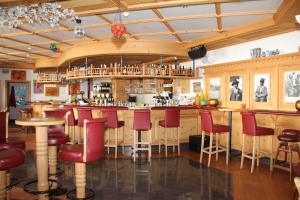 een bar in een restaurant met rode krukken bij Wellness Hotel Post in Solda
