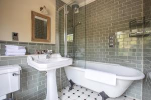 a bathroom with a sink and a tub and a toilet at The Running Horses in Mickleham