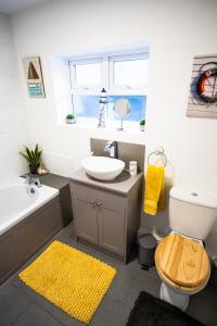 a bathroom with a sink and a toilet and a mirror at Sunrise Beach House in Cleethorpes