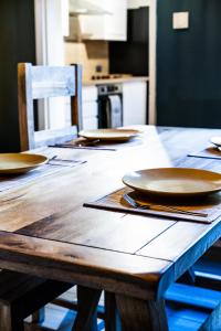 una mesa de madera con platos en la cocina en Sunrise Beach House en Cleethorpes