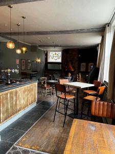 a restaurant with tables and chairs and a bar at The White Hart in Whitchurch