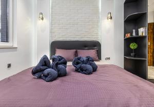 a bedroom with a purple bed with two sloth cushions at Modern 1BD Flat with a Parking near the city centre in Plovdiv