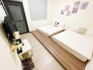 a small room with two beds and a tv at Fengjia AS House in Taichung