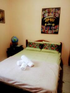 a stuffed animal laying on a bed in a bedroom at Casa aconchegante térrea à 3min de carro do centro e praia central in Garopaba