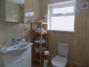 uma casa de banho com um lavatório, um WC e uma janela. em The Railway House em Cardiff