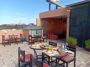 a patio with tables and chairs on a roof at Dar HAJAR in Marrakech