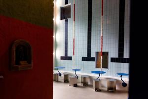 Une rangée de ools avec des tables bleues dans une pièce dans l'établissement Hotel Not Hotel Rotterdam, à Rotterdam